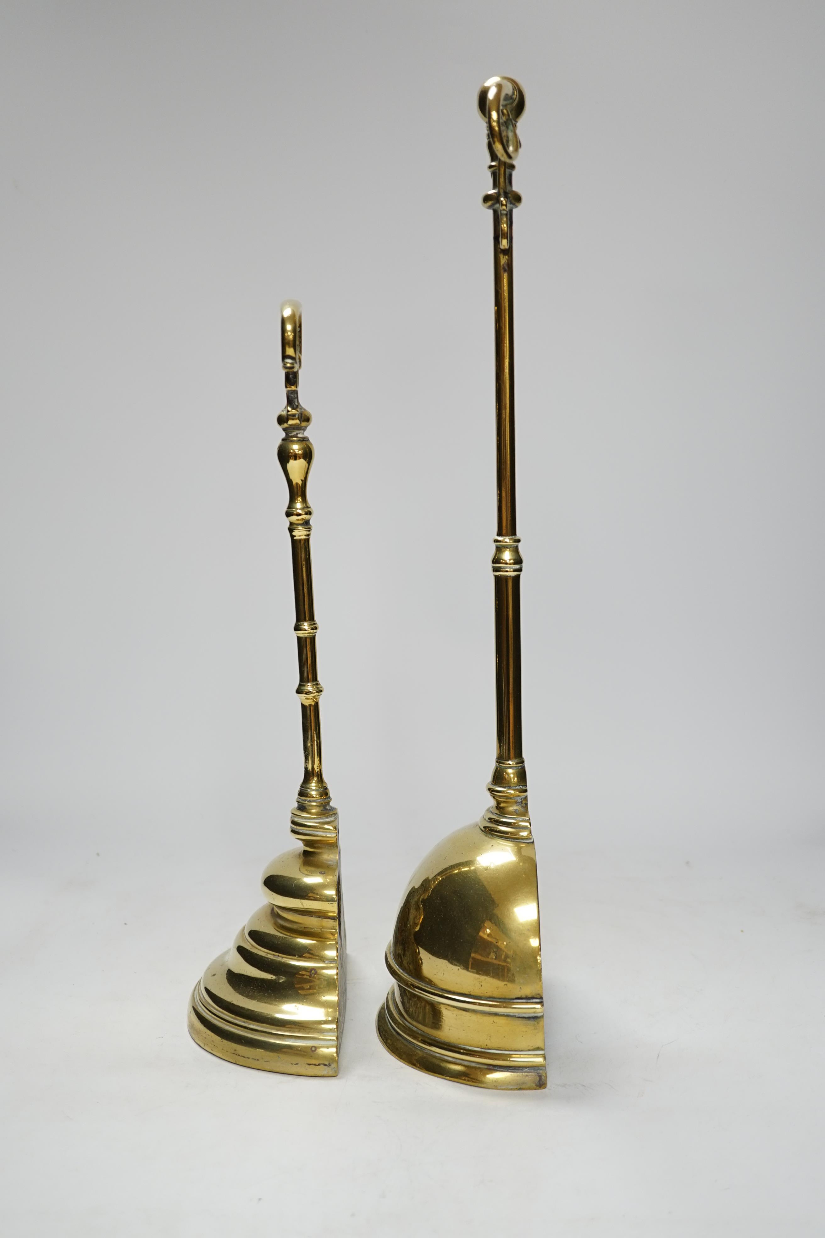Two early 19th century cast brass door stops, with moulded stepped plinths, largest 45cm high
